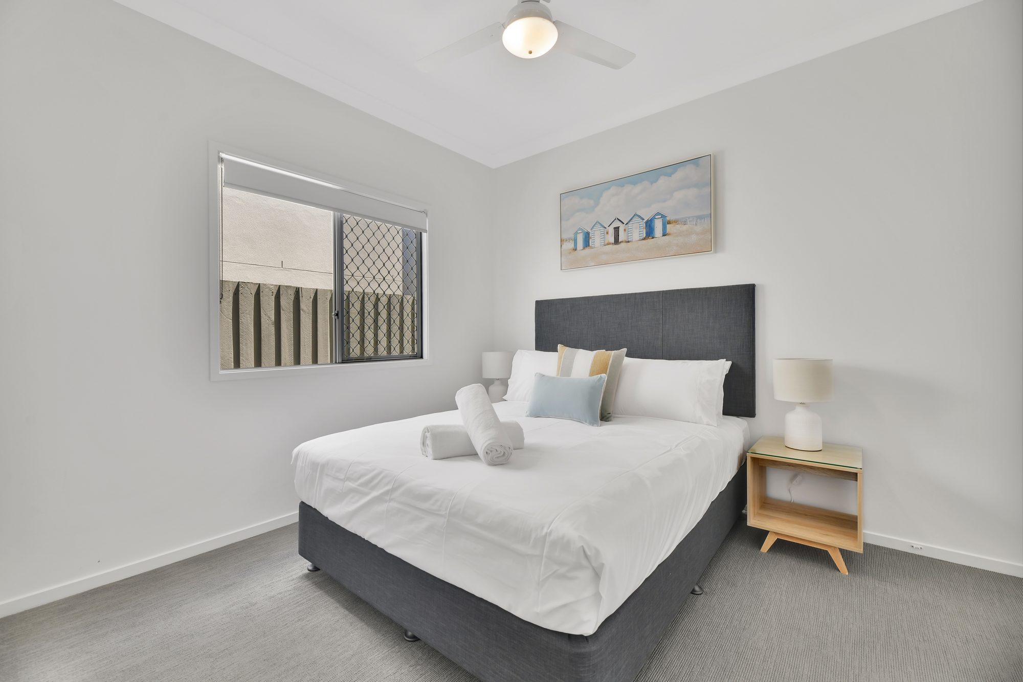 Queen bedroom with coastal styling and natural light