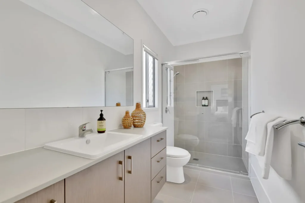 Bathroom with glass-screened shower, vanity and toilet
