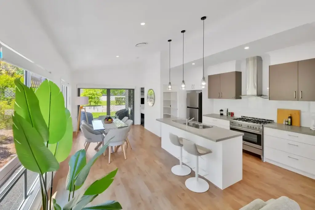 Open-plan kitchen and dining area with pendant lights and sliding doors to the garden