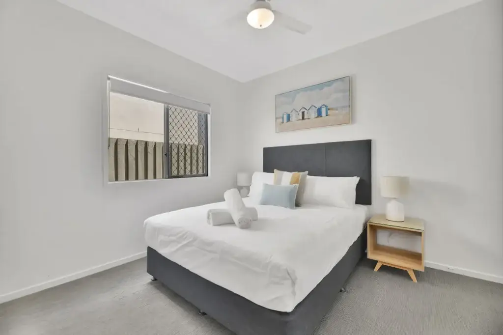 Queen bedroom with coastal styling and natural light