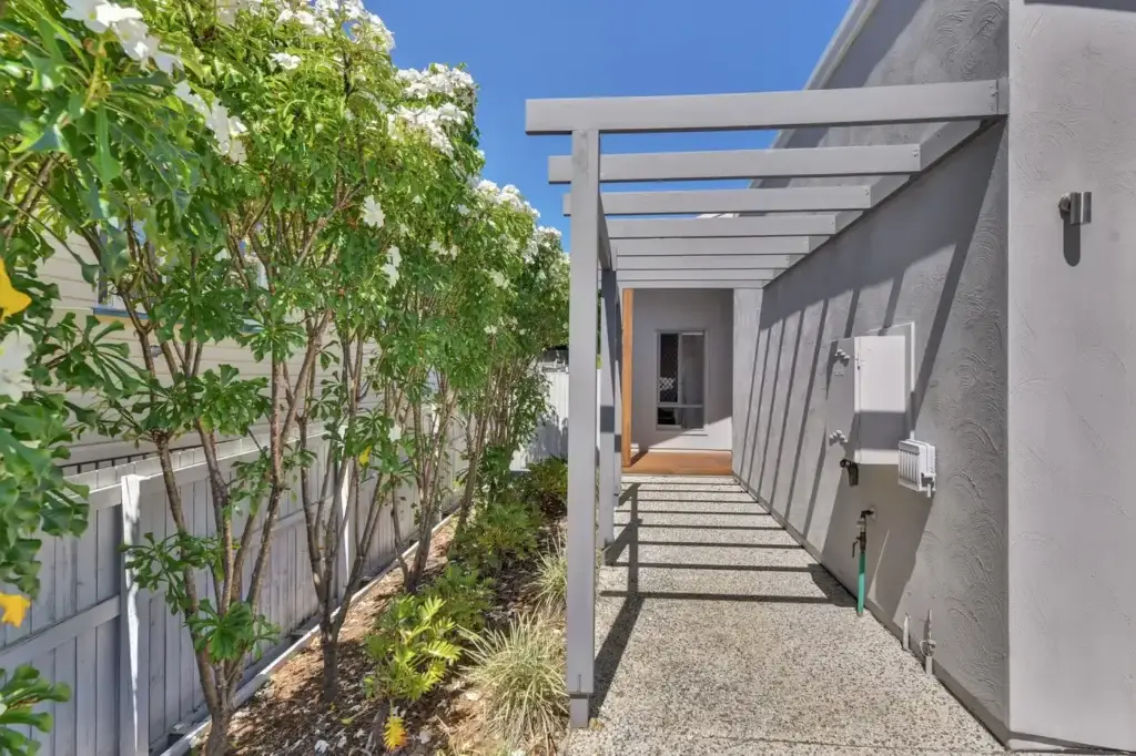 Private side entrance with pergola walkway and frangipani at the Scarborough villa